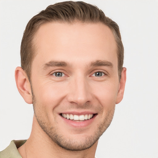 Joyful white young-adult male with short  brown hair and grey eyes