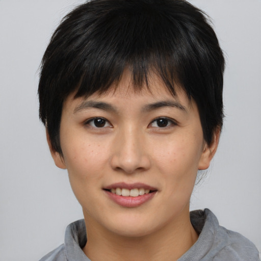 Joyful asian young-adult female with short  brown hair and brown eyes