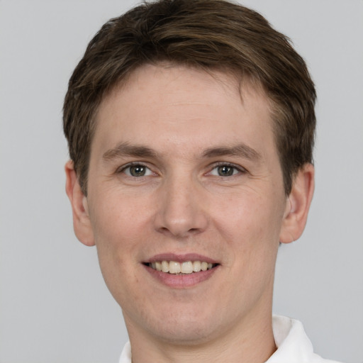 Joyful white young-adult male with short  brown hair and grey eyes