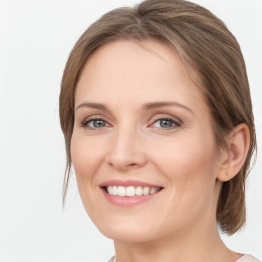 Joyful white young-adult female with medium  brown hair and grey eyes