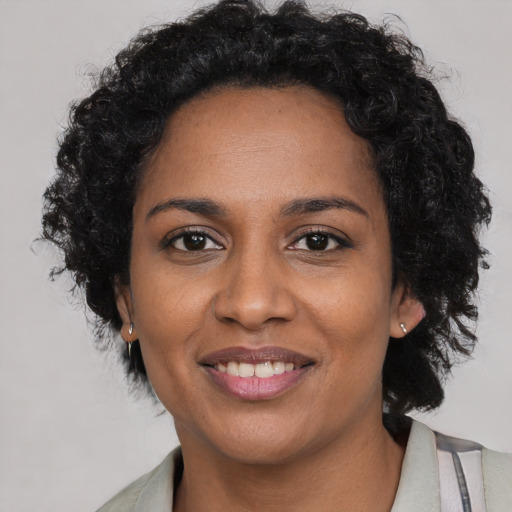 Joyful black adult female with long  brown hair and brown eyes