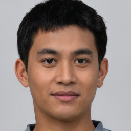 Joyful asian young-adult male with short  black hair and brown eyes