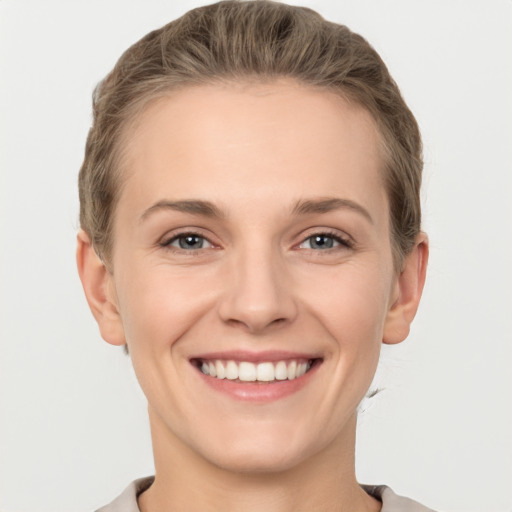 Joyful white young-adult female with short  brown hair and grey eyes