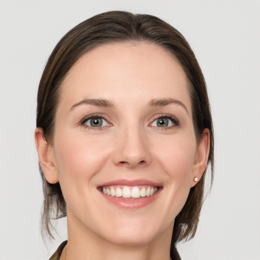 Joyful white young-adult female with medium  brown hair and grey eyes