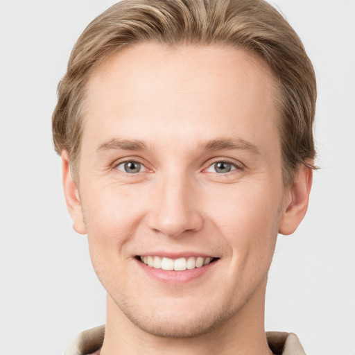 Joyful white young-adult male with short  brown hair and grey eyes