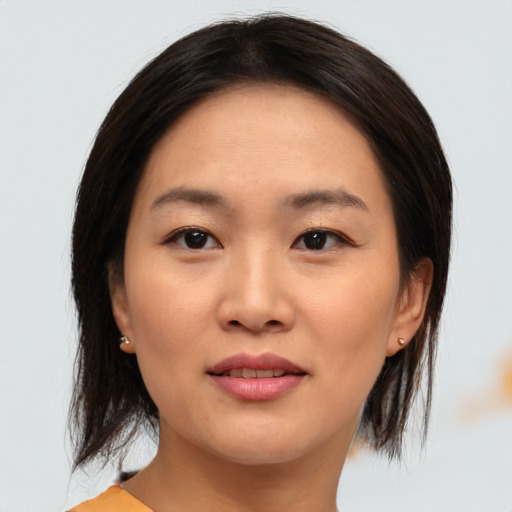 Joyful asian young-adult female with medium  brown hair and brown eyes