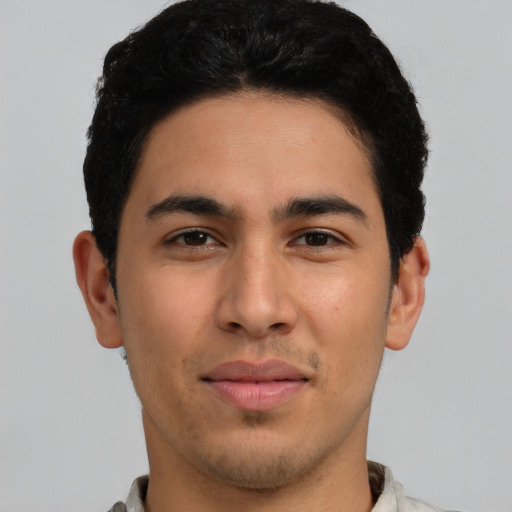 Joyful latino young-adult male with short  black hair and brown eyes