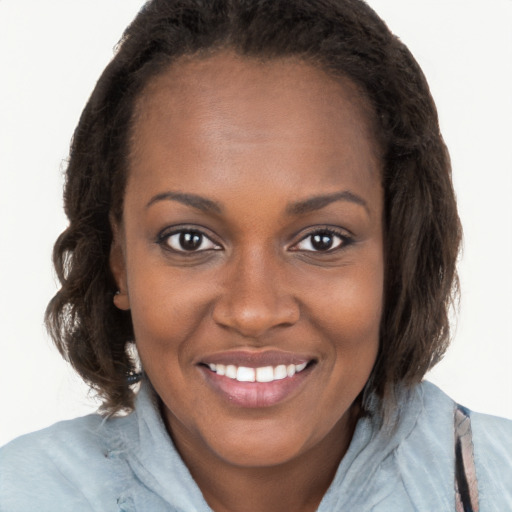 Joyful black young-adult female with long  brown hair and brown eyes