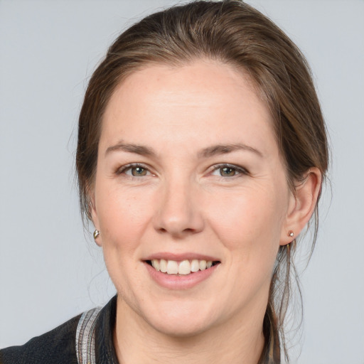 Joyful white adult female with medium  brown hair and grey eyes