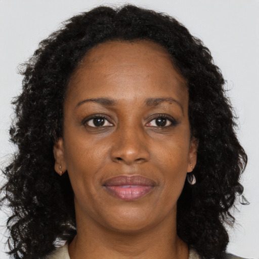 Joyful black adult female with long  brown hair and brown eyes
