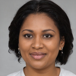 Joyful black adult female with medium  brown hair and brown eyes