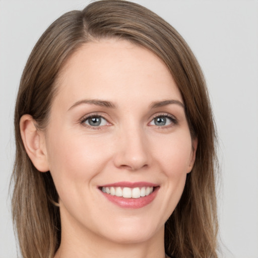 Joyful white young-adult female with long  brown hair and grey eyes