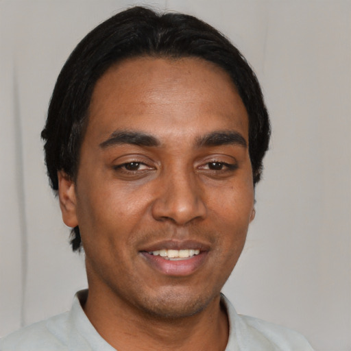 Joyful black young-adult male with short  black hair and brown eyes
