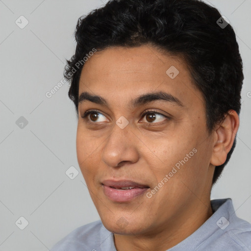 Joyful latino young-adult male with short  black hair and brown eyes