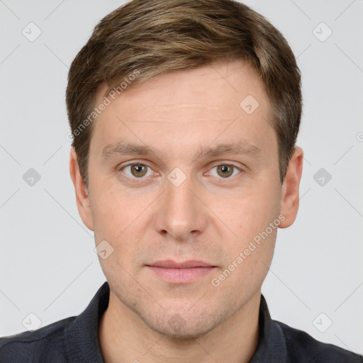 Joyful white young-adult male with short  brown hair and grey eyes