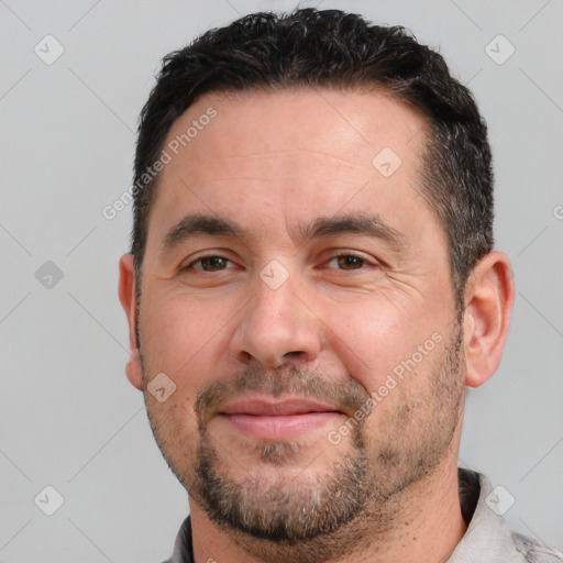 Joyful white adult male with short  black hair and brown eyes