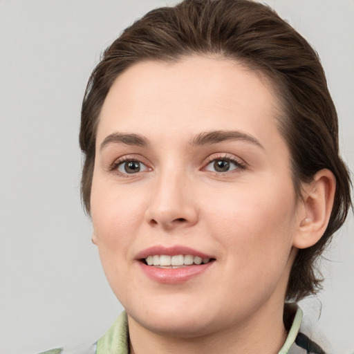 Joyful white young-adult female with medium  brown hair and grey eyes