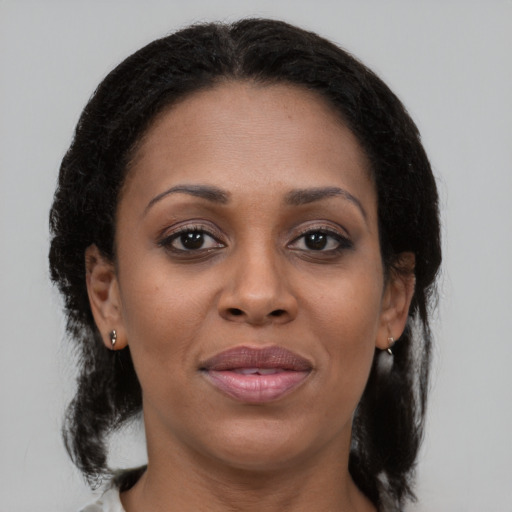 Joyful black adult female with medium  brown hair and brown eyes