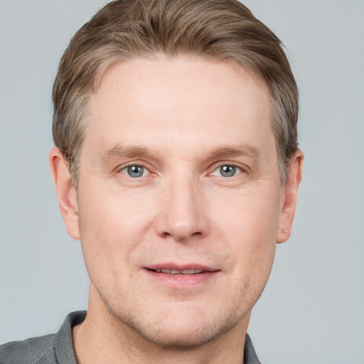 Joyful white adult male with short  brown hair and grey eyes