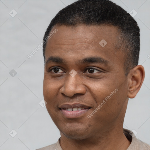 Joyful black young-adult male with short  black hair and brown eyes