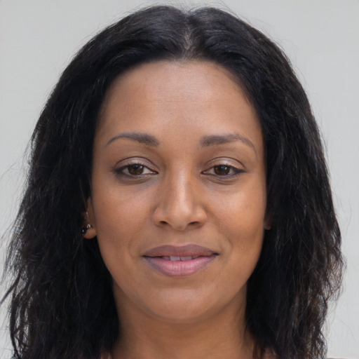 Joyful black young-adult female with long  brown hair and brown eyes