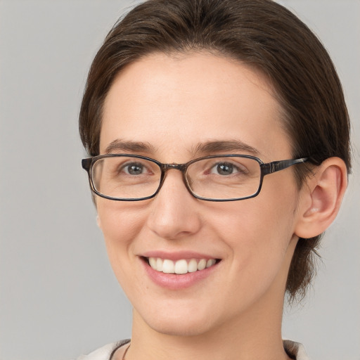 Joyful white young-adult female with medium  brown hair and grey eyes