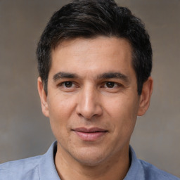 Joyful white adult male with short  black hair and brown eyes