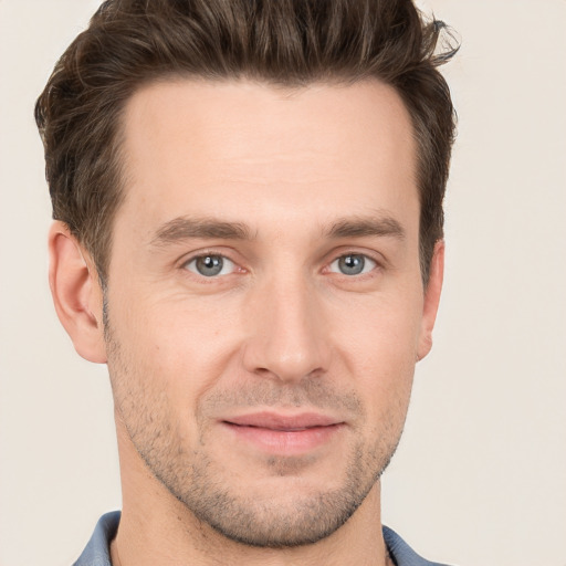 Joyful white young-adult male with short  brown hair and grey eyes