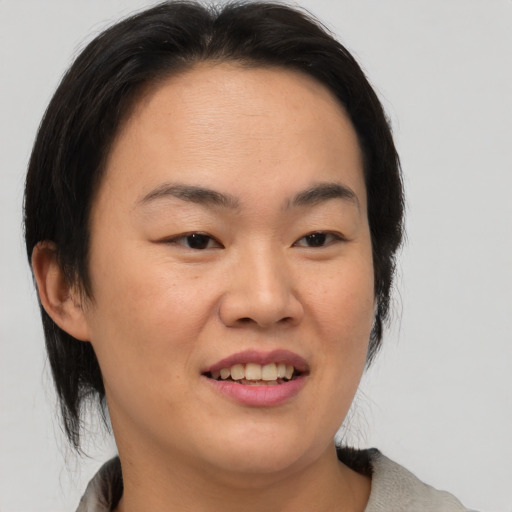Joyful asian young-adult female with medium  brown hair and brown eyes