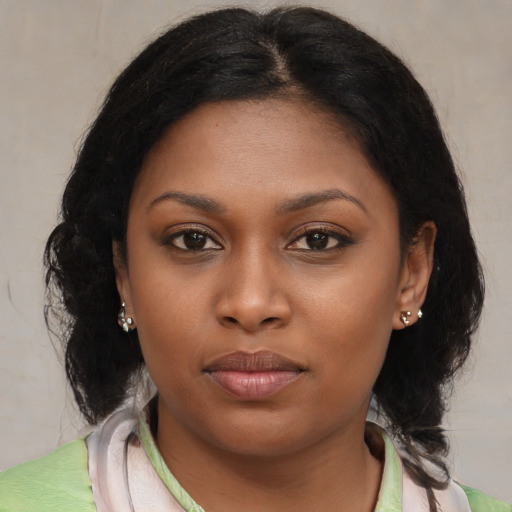 Joyful black young-adult female with medium  brown hair and brown eyes