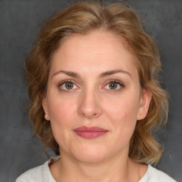 Joyful white adult female with medium  brown hair and blue eyes