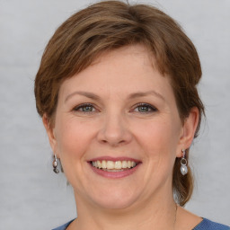 Joyful white young-adult female with medium  brown hair and blue eyes