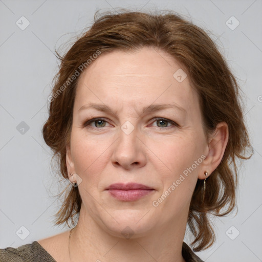 Joyful white adult female with medium  brown hair and blue eyes