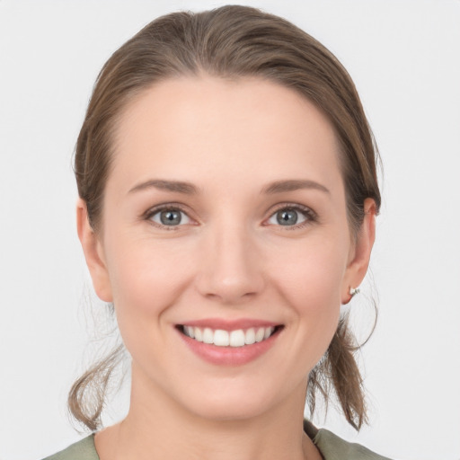 Joyful white young-adult female with medium  brown hair and grey eyes