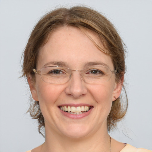 Joyful white adult female with medium  brown hair and blue eyes