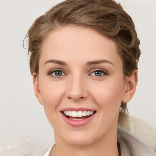 Joyful white young-adult female with short  brown hair and grey eyes