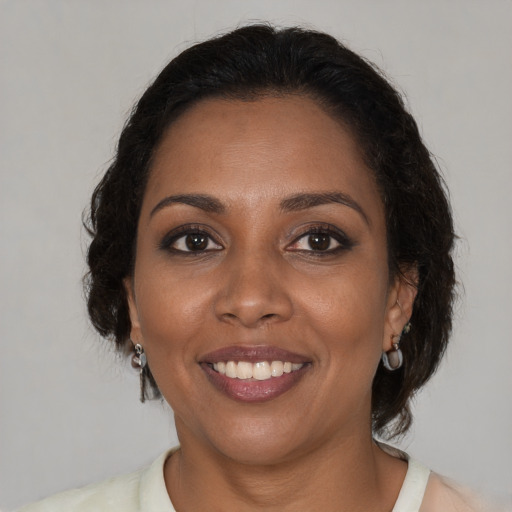 Joyful black adult female with medium  brown hair and brown eyes