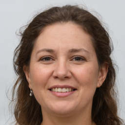 Joyful white adult female with long  brown hair and grey eyes