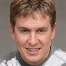 Joyful white adult male with short  brown hair and grey eyes