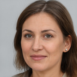 Joyful white adult female with long  brown hair and brown eyes