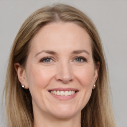 Joyful white adult female with long  brown hair and grey eyes