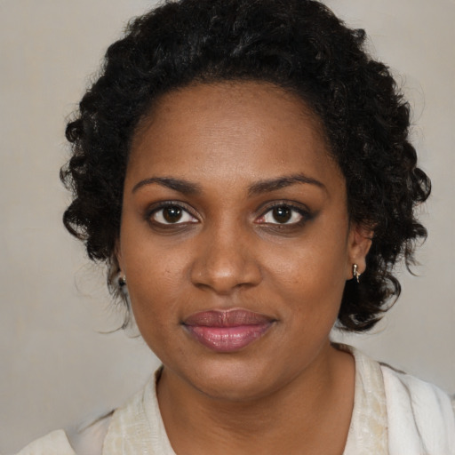 Joyful black young-adult female with medium  brown hair and brown eyes