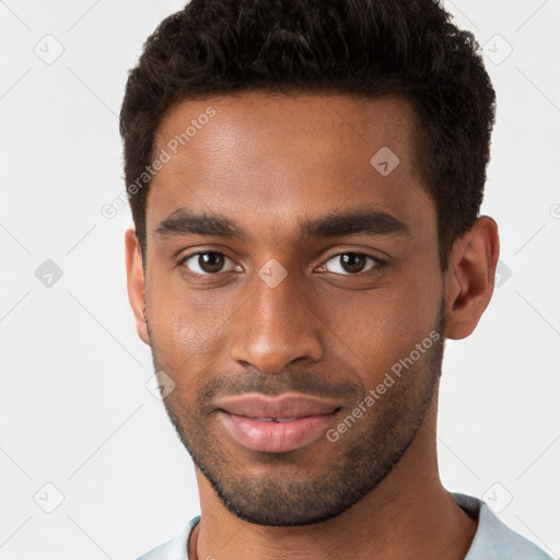 Joyful black young-adult male with short  brown hair and brown eyes