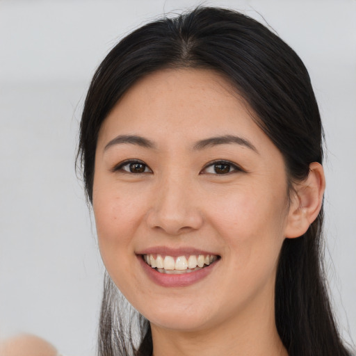 Joyful asian young-adult female with long  brown hair and brown eyes