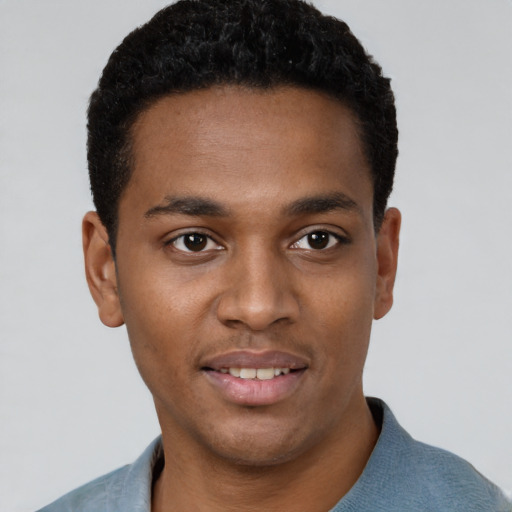 Joyful black young-adult male with short  black hair and brown eyes