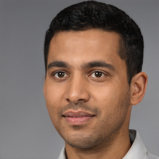 Joyful latino young-adult male with short  black hair and brown eyes