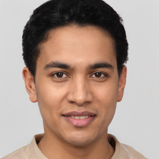 Joyful latino young-adult male with short  black hair and brown eyes