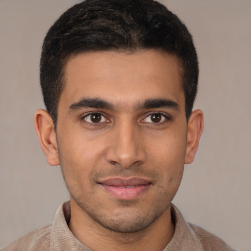 Joyful latino young-adult male with short  brown hair and brown eyes