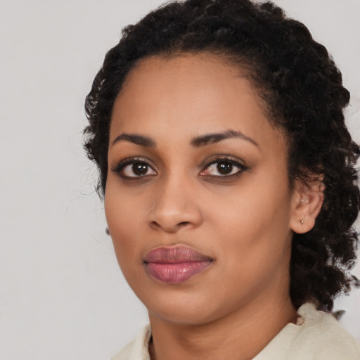 Joyful black young-adult female with medium  black hair and brown eyes