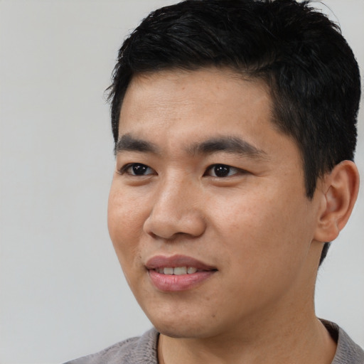 Joyful asian young-adult male with short  black hair and brown eyes